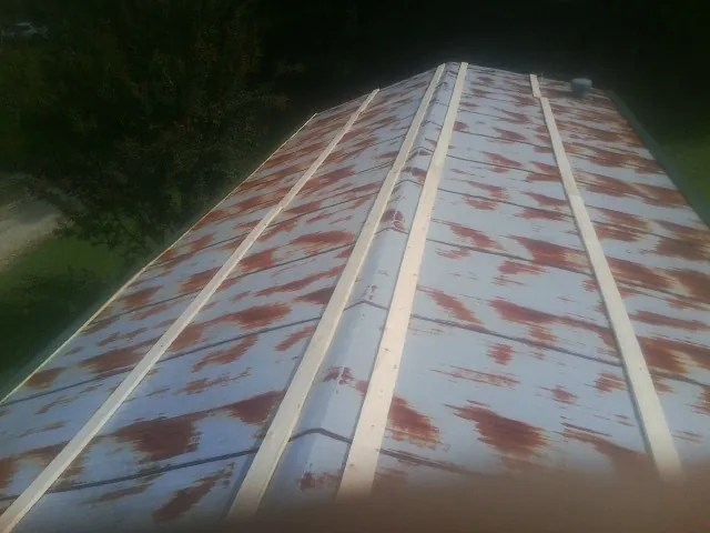 Rusted metal roof panels with new wood purlins before replacement — Storm Damage Roof Repair in Price by Roofing Brothers