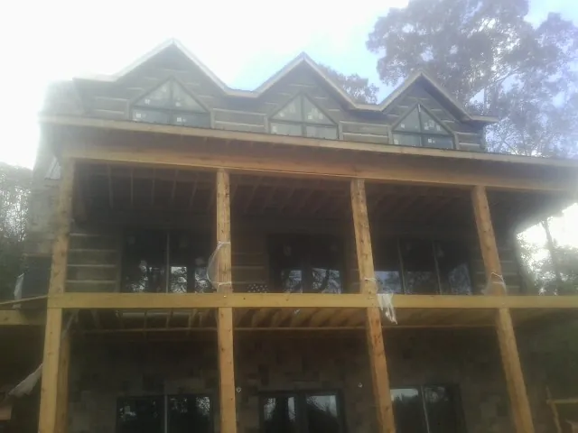 Dormers and porch framing on a large log home under construction — Roof Coating work by our crew in Price