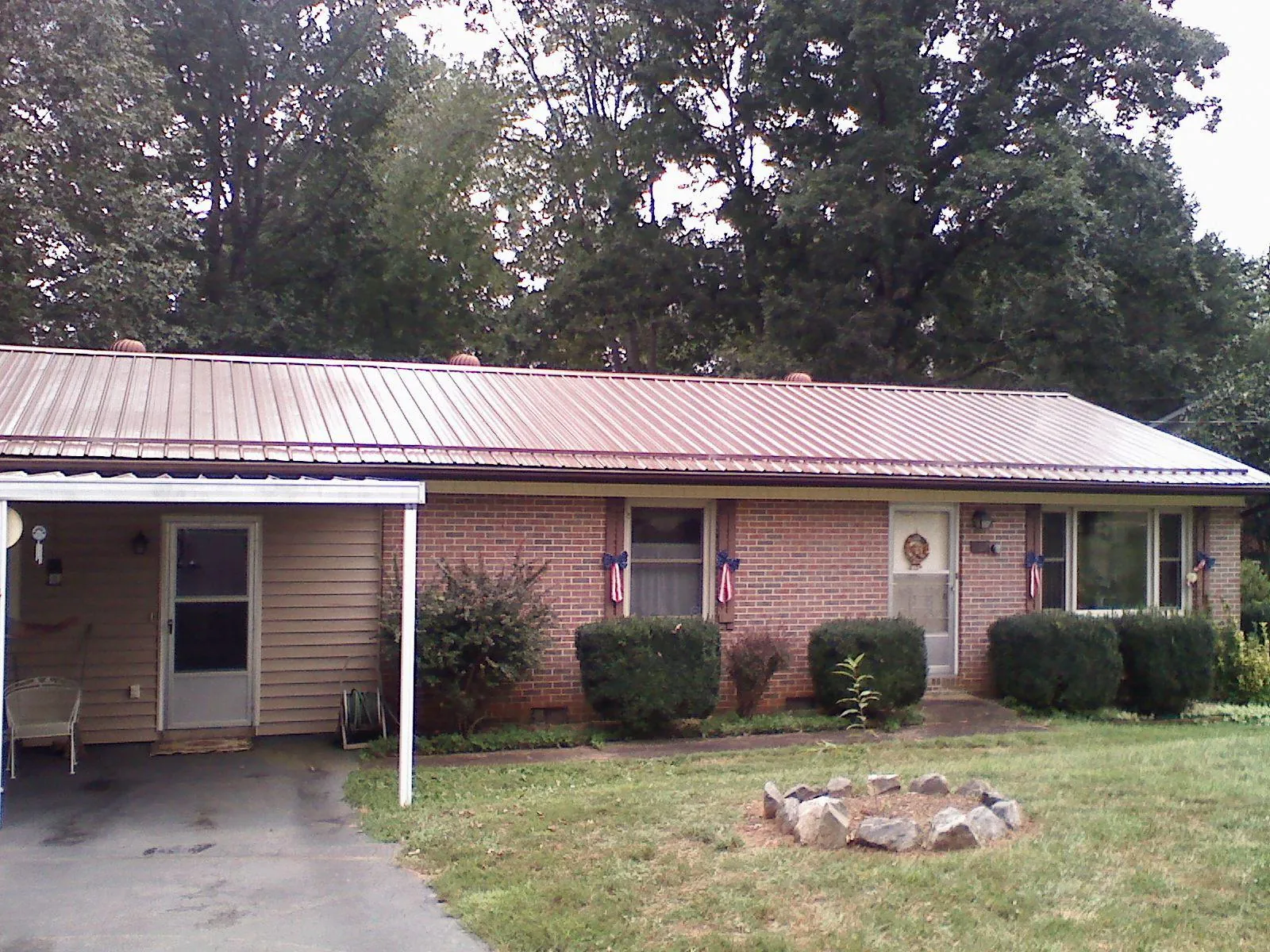 Bronze metal roof and carport on a brick ranch home — Roof Repair work by our crew in Price